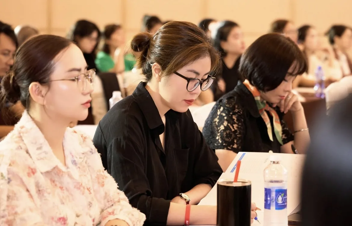 Chủ cơ sở làm đẹp người Việt ngồi ghi chép lại các mốc cần nhớ liên quan tới bỏ thuế khoán hộ kinh doanh 2026 trong sổ tay đặt trên bàn