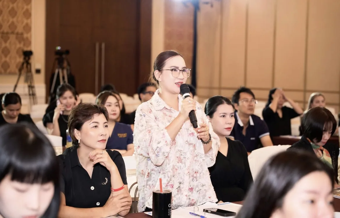 Học viên là chủ tiệm giơ tay hỏi lại một chi tiết về hộ kinh doanh doanh thu bao nhiêu phải nộp thuế trong buổi hướng dẫn, không khí tập trung